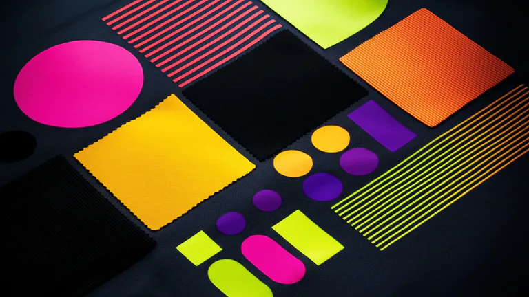 Composición conceptual de muestras de color CMYK y formas geométricas impresas en tela para identidad de marca corporativa