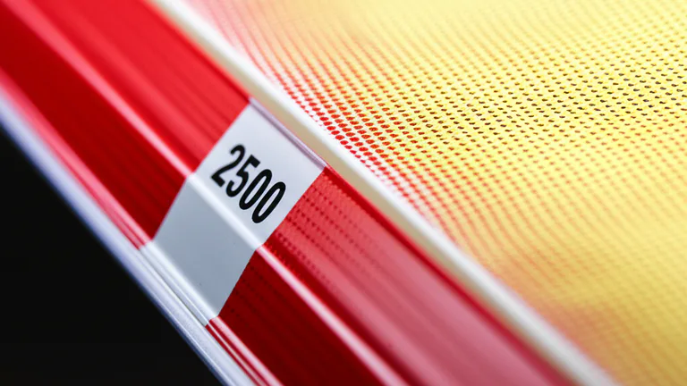 Detalle macro de cenefas y copetes de anaquel en góndola de supermercado con impresión a color de alta definición