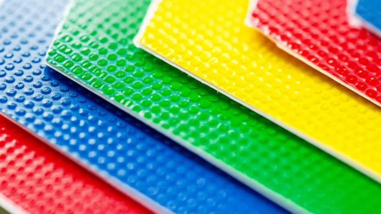 Detalle macro de láminas de vinil impreso multicapa con tintas CMYK para material POP de retail