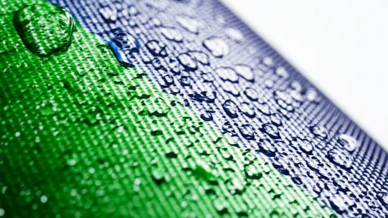 Detalle macro de la textura de lona vinílica con tintas CMYK y resistencia al agua visible