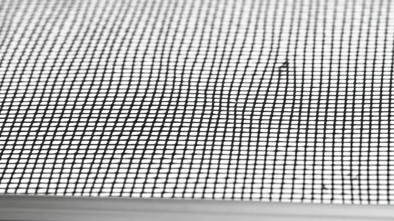 Macro detalle de malla de poliéster tensada en marco de aluminio mostrando el patrón geométrico de hilos para serigrafía