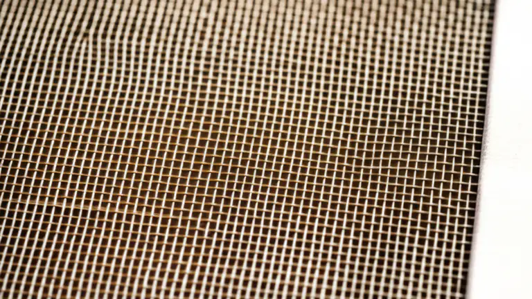 Macro detalle de malla serigráfica de alta densidad mostrando la estructura de hilos tensados en bastidor metálico