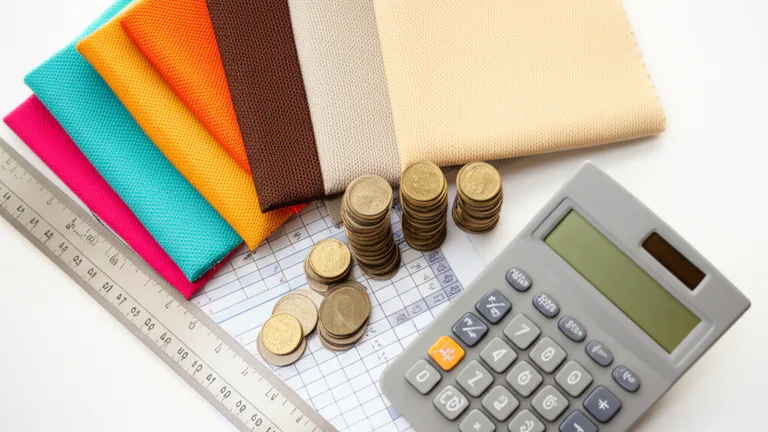 Vista cenital de muestras de piezas serigrafiadas junto a calculadora y monedas simulando análisis de costo por pieza