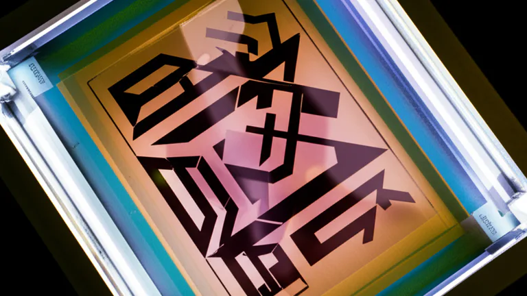 Vista cenital de película positiva colocada sobre pantalla emulsionada lista para exposición UV en el proceso de quemado de serigrafía