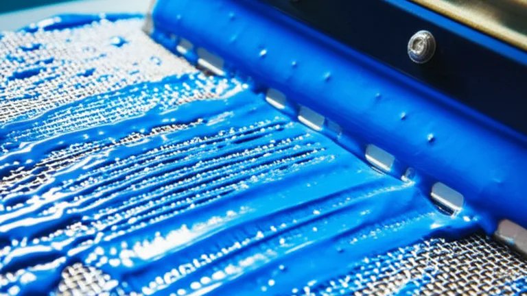 Vista macro del proceso de emulsionado de malla serigráfica con emulsión fotosensible azul aplicada con rasero